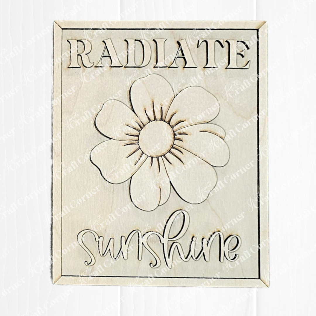 Create your own Radiate Sunshine Farmhouse Sign from Janet's Craft Corner with a DIY kit featuring a wooden plaque engraved with a large flower. The words "RADIATE" at the top and "sunshine" at the bottom complete this charming design, along with included wood cut-outs.