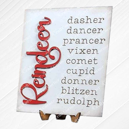 The Reindeer Farmhouse Sign from Janet's Craft Corner features a charming decorative display.  It lists the names of Santa's reindeer in two columns: "Dasher, Dancer, Prancer, Vixen, Comet, Cupid, Donner, Blitzen, Rudolph," with the word "Reindeer" hand-painted in red vertically on the left.