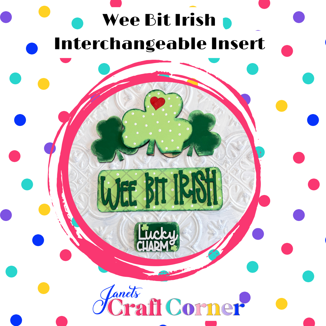 Janet's Craft Corner offers the "Wee Bit Irish Interchangeable Insert," an engaging home decor piece featuring "Wee Bit Irish" and "Lucky Charm" text with green clovers and a red heart on a polka-dot background, perfect for celebrating your Irish pride.