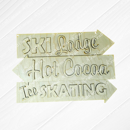 Janet's Craft Corner's Ski Lodge Directory Sign features hand-painted wooden directional signs with black script text pointing to "Ski Lodge," "Hot Cocoa," and "Ice Skating" on a textured white background, ideal for adding rustic charm to your home décor.