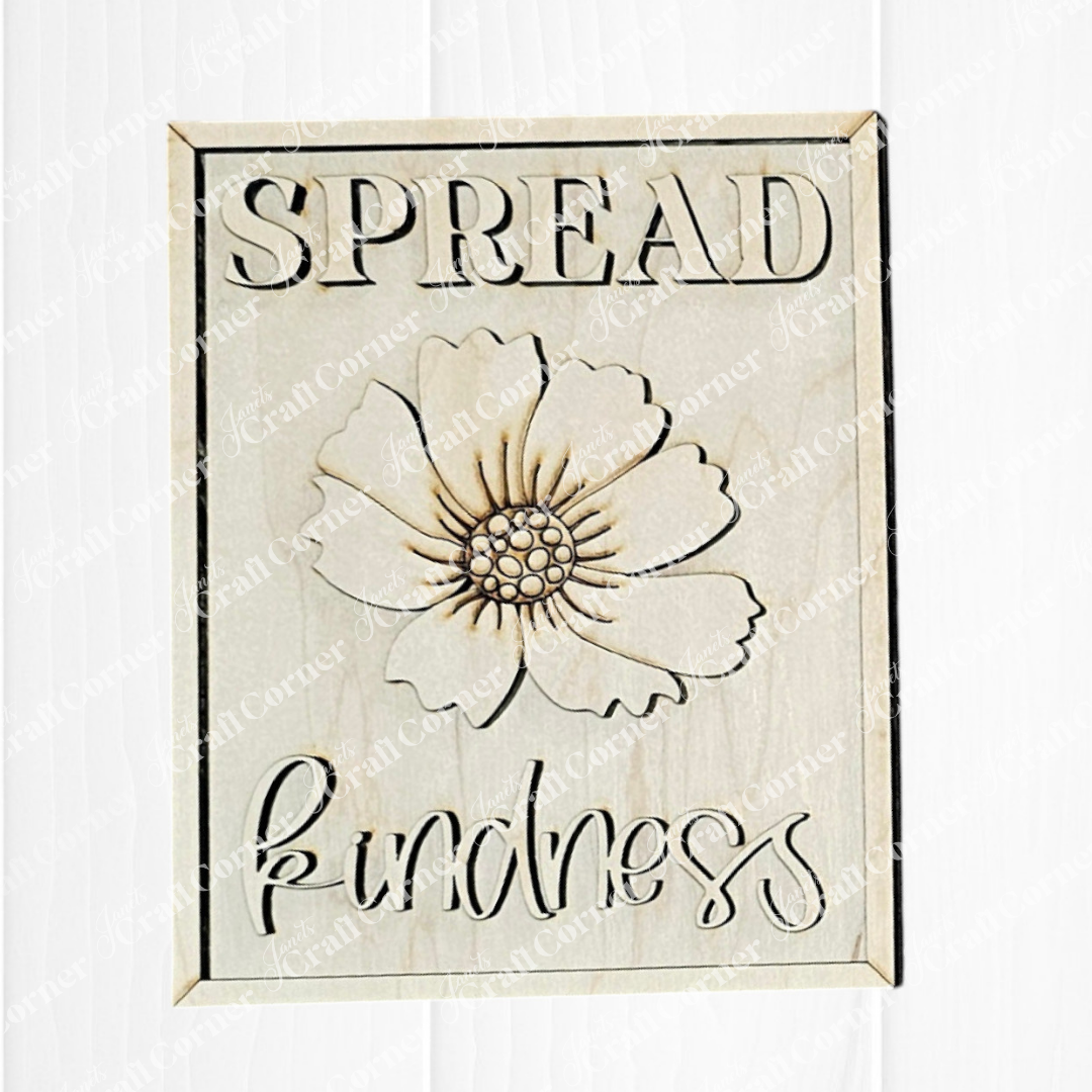 The Spread Kindness Farmhouse Sign by Janet's Craft Corner features wooden wall art with a central carved flower, ideal for tiered trays or small spaces. "SPREAD kindness" is elegantly engraved above and below the flower on a white background.