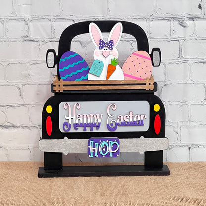 Janet's Craft Corner offers an Antique Truck Base with Insert, a DIY home decor kit featuring an antique truck labeled "Happy Easter" and "HOP," carrying colorful eggs and a bunny with a carrot against a white brick wall on burlap, perfect for charming seasonal decor.