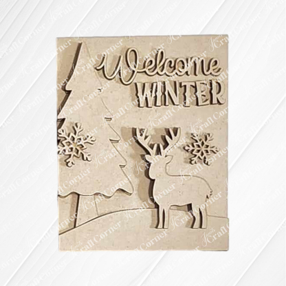 The Welcome Winter Sign from Janet's Craft Corner is a hand-painted wooden plaque showcasing "Welcome Winter" text, adorned with a tree, two snowflakes, and a reindeer. It's an ideal piece of charming home decor to celebrate the season's arrival.