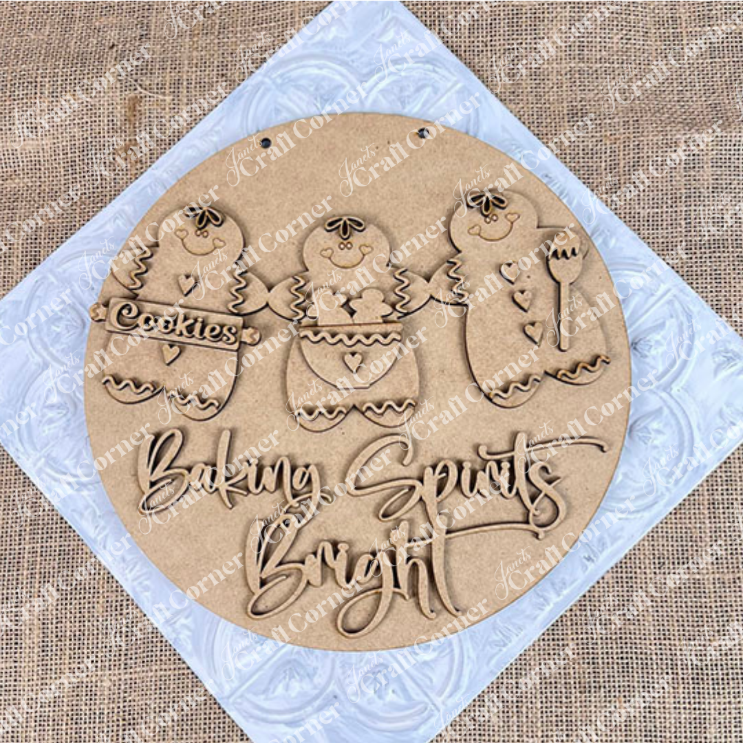 Janet's Craft Corner's Baking Spirits Bright Wall Hanger DIY kit features three gingerbread figures with a "Cookies" sign and "Baking Spirits Bright" engraved below, perfect for adding festive charm to your seasonal home decor. Set of 1.