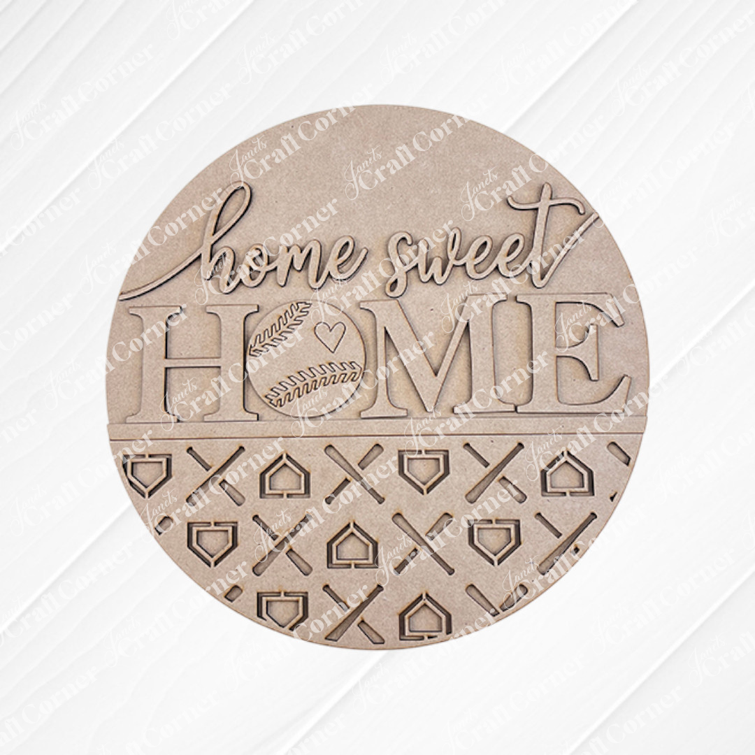 Introducing the "Baseball Home Sweet Home Round" from Janet's Craft Corner. This round wooden DIY sign showcases the phrase "home sweet HOME" along with a baseball door hanger design. The bottom half features intricate cut-out patterns set against a burlap background, and the kit conveniently includes "DIY KIT" labeled in the corner.