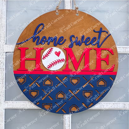 Crafted by Janet's Craft Corner, the Baseball Home Sweet Home Round is a round wooden door hanger featuring "home sweet HOME" emblazoned in blue and red. The "O" in "HOME" is cleverly designed as a baseball with a red heart, accented by a striking blue pattern. This delightful piece of home decor hangs elegantly by rope against a glass window and is an ideal addition for any DIY kit enthusiast.