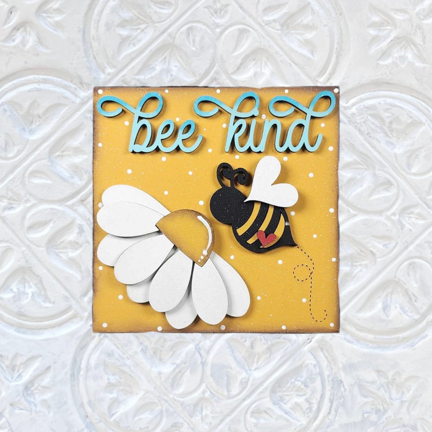 Bee Swappable Squares by Janet's Craft Corner: A handmade card with a bee and daisy on yellow, blue "bee kind" script, white dots, and embossed border—charming for gifts or cheerful decor.