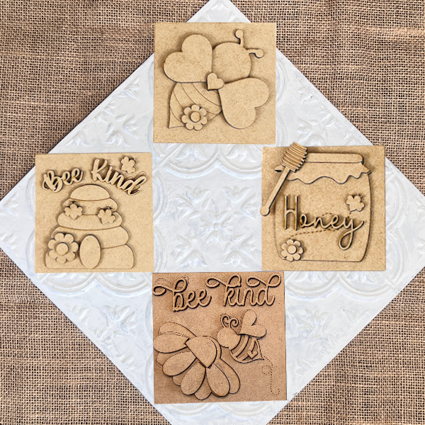 Bee Swappable Squares by Janet's Craft Corner: set of four wooden plaques featuring bee and honey-themed designs, such as flowers, a "Honey" jar, and "Bee Kind" text—handmade charm for your home décor.
