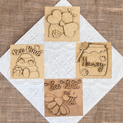 Bee Swappable Squares by Janet's Craft Corner: set of four wooden plaques featuring bee and honey-themed designs, such as flowers, a "Honey" jar, and "Bee Kind" text—handmade charm for your home décor.