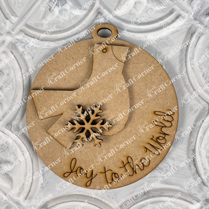 Introducing Janet's Craft Corner's Round Christmas Ornaments from the DIY Decoration Kits! This delightful wooden ornament is shaped like a bird and adorned with a snowflake, featuring "joy to the world" engraved on it. It's beautifully complemented by a textured white background, making it a charming addition to your holiday decor.