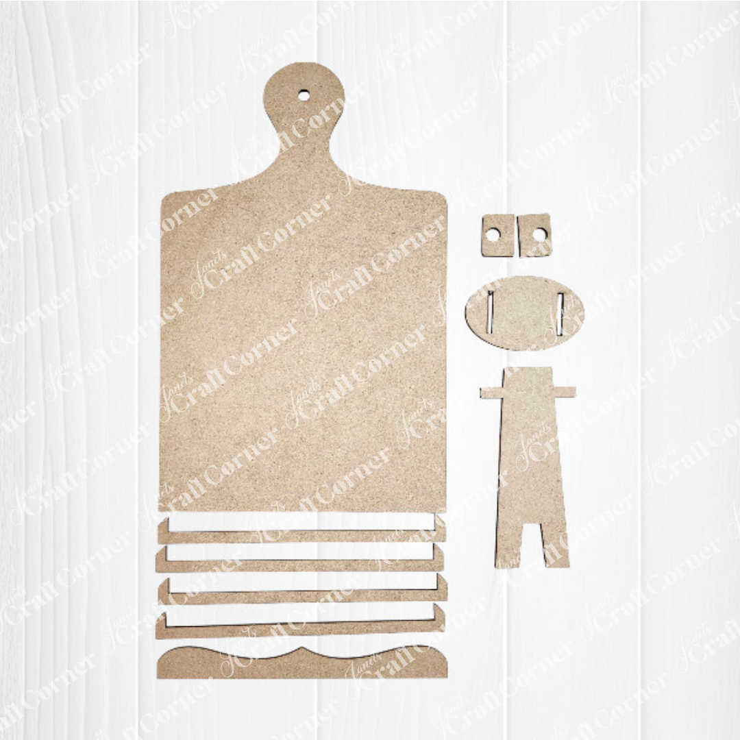 The Breadboard Sign Holder DIY home decor craft kit from Janet's Craft Corner features a collection of MDF board pieces arranged on a white surface. The set includes a paddle-shaped piece, rectangular strips, a curved piece, small rectangular pieces with holes, and a stand-like figure—perfect for crafting charming interchangeable signs.