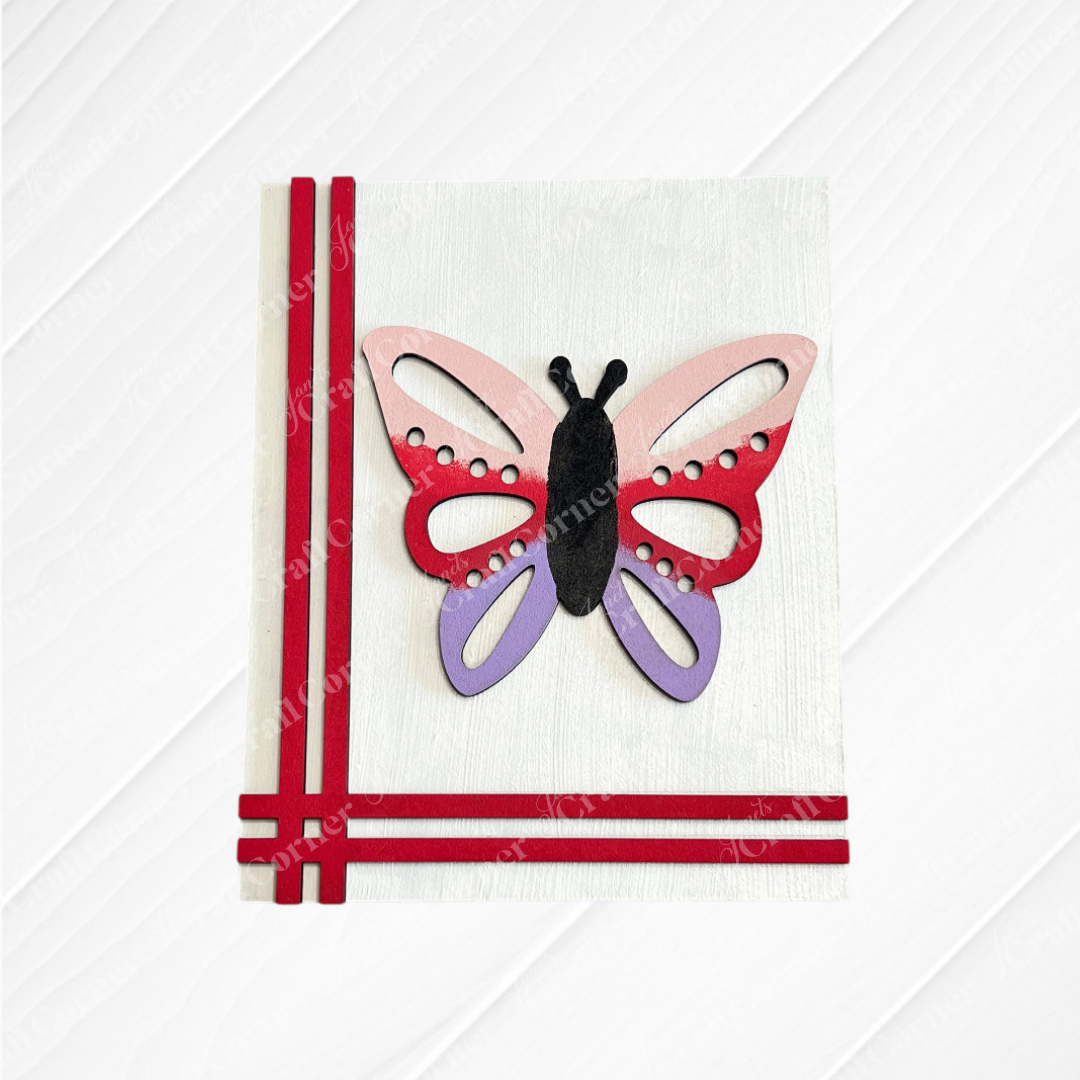 The Spring Switchable Farmhouse Signs DIY Kit by Janet’s Craft Corner features a handmade card with a large pink, red, and purple butterfly cutout and red ribbon accents—ideal for lavender-inspired decor or tiered tray displays.