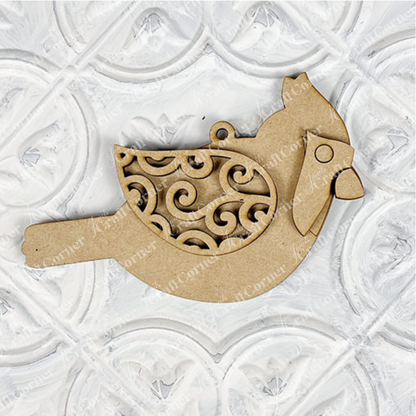 Introducing the Cardinal Ornament from Janet's Craft Corner—a DIY decoration kit featuring a cardinal bird crafted from wood, adorned with intricate swirl patterns on its wings and set against a white embossed, patterned background. Ideal for holiday décor or as a hand-painted craft project.