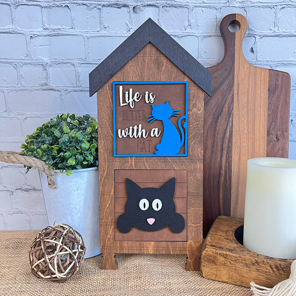 Janet's Craft Corner Cat Swappable Squares: This wooden, house-shaped sign with "Life is better with a cat," blue cat silhouette, and black cat face is perfect small-space or seasonal DIY decor. Display on a table with plants or candles.