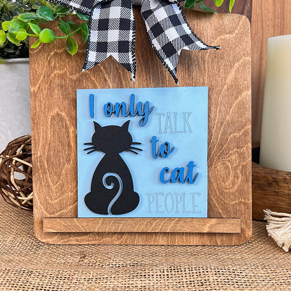 The Cat Swappable Squares by Janet's Craft Corner feature a black cat silhouette and blue, black, and white text that says "I only talk to cat people," finished with a checkered bow and green faux foliage—perfect for small spaces.