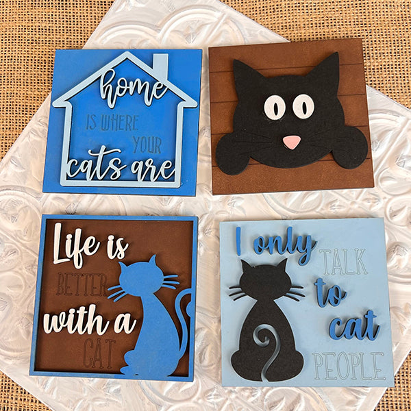 Janet's Craft Corner Cat Swappable Squares are four blue and brown coasters with cat designs and sayings like “Home is where your cats are.” Perfect DIY seasonal decor for small spaces.