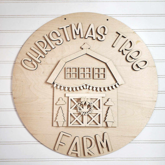 The Christmas Tree Farm Door Hanger DIY Decor Kit by Janet's Craft Corner features the phrase "Christmas Tree Farm" surrounding a barn design. This delightful home décor piece displays a garland wreath on the door, accompanied by two Christmas trees, all in a natural wood finish, perfect for a hand-painted DIY craft project.