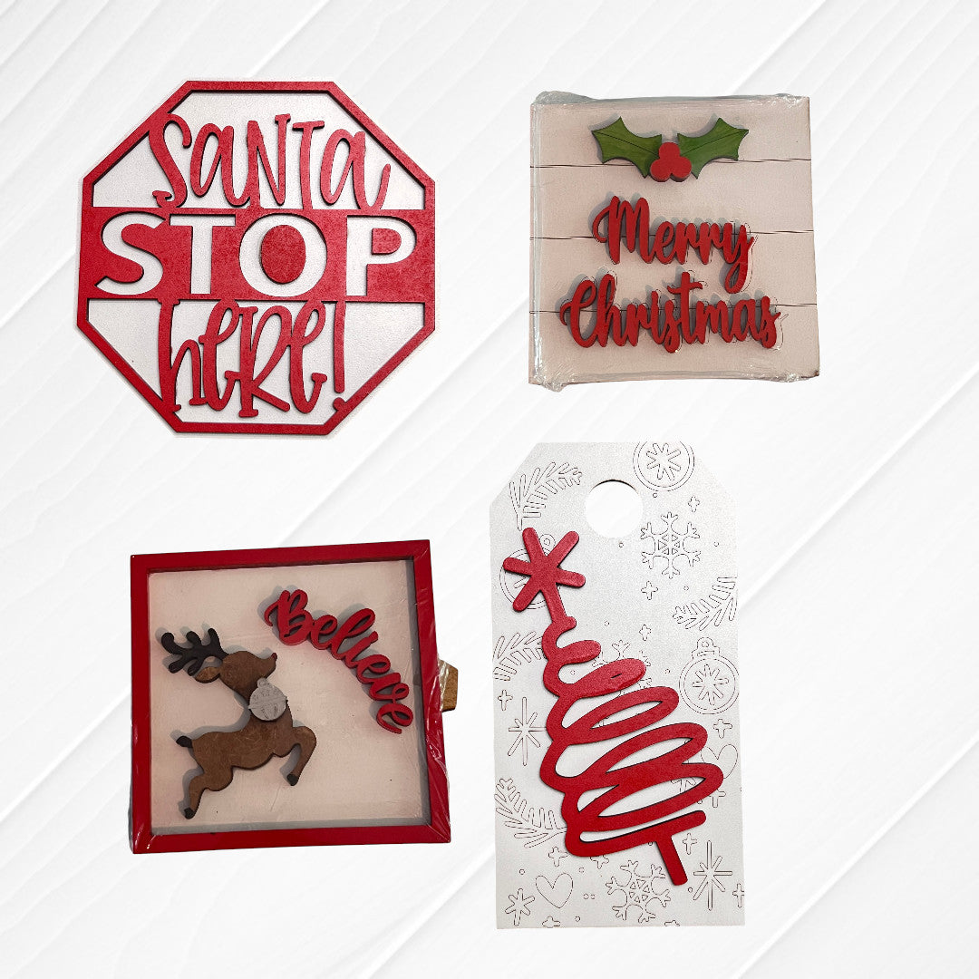 Janet's Craft Corner Christmas Mini Shelf Sitters: a red "Santa STOP here!" sign, "Merry Christmas" holly plaque, framed reindeer with "Believe," and a gift tag featuring a red spiral tree on white.