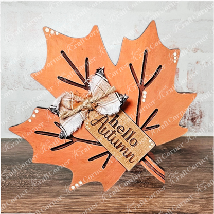 The Fall Chunky Mini Shelf Sitters by Janet's Craft Corner is a DIY seasonal home decor kit featuring an orange autumn leaf with white dots, a plaid bow, and a "hello Autumn" tag—an ideal mini shelf decor or fall shelf sitter.