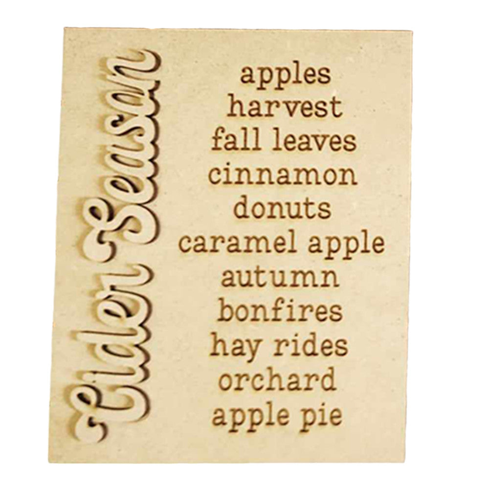 The image beautifully showcases Janet's Craft Corner's "Cider Words Interchangeable Sign" DIY home decor craft kit. The wooden sign, engraved with "Cider Season," is complemented on the right by lively words that evoke apples, harvest, and fall leaves. Together, they conjure the cozy essence of autumn with cinnamon donuts, caramel apple treats, bonfires, hay rides at the orchard, and apple pie delights.