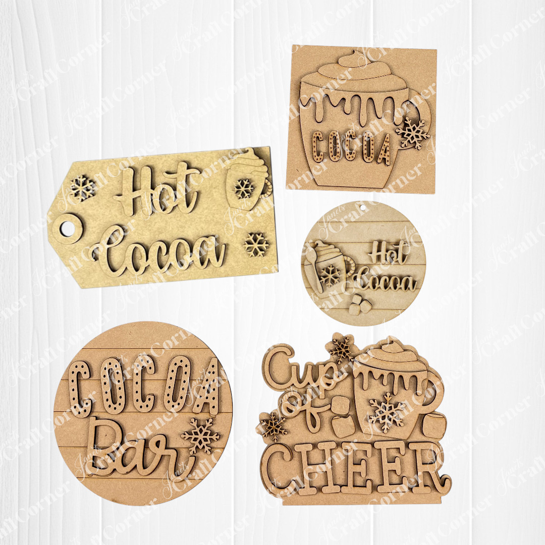 Janet's Craft Corner Hot Cocoa Mini Shelf Sitters is a DIY seasonal home decor kit with 5 wooden cutouts featuring mugs, snowflakes, and phrases like “Hot Cocoa” and “Cup of Cheer”—ideal for hot cocoa bar displays. Set of 1.