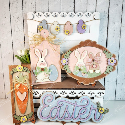 Janet's Craft Corner's Easter Decor Set is a DIY seasonal home decor kit with 5 handcrafted pieces—bunny, eggs, carrot, flowers, and "Easter" sign in pastels—all set against a white wooden background.