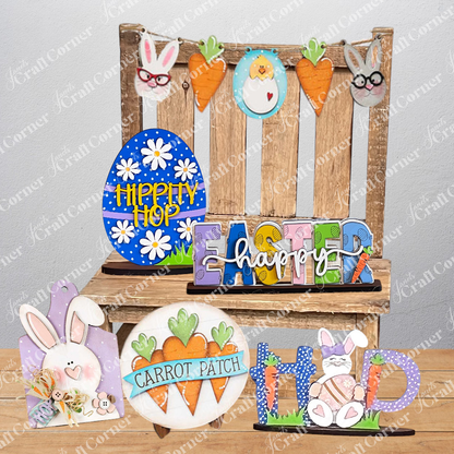 Discover Janet's Craft Corner's "Easter Trio Mini Shelf Sitters," which includes a wooden display featuring "HOP" complete with a bunny and carrots, an egg adorned with "HIPPITY HOP," and vibrant letters spelling out "EASTER happy." Ideal for a DIY kit project, these delightful shelf sitters are beautifully presented on burlap set against a white brick backdrop.