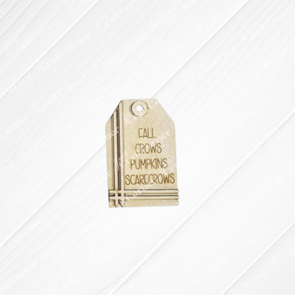 Janet's Craft Corner Fall Scarecrow Mini Shelf Sitters DIY kit features a small rectangular beige tag engraved with "FALL," "CROWS," "PUMPKINS," and "SCARECROWS"—perfect for your autumn decor. Set of 1.