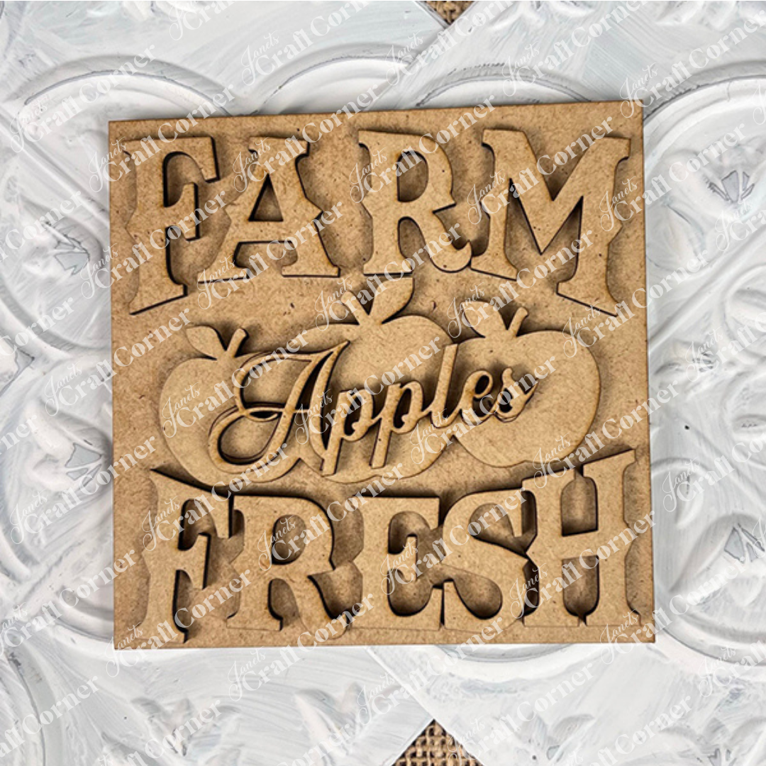 Janet's Craft Corner Farm Fresh Apples Square: Wooden sign with "FARM FRESH Apples" cutout letters and three apple shapes, ideal for DIY home decor in small spaces, displayed on a white textured surface.