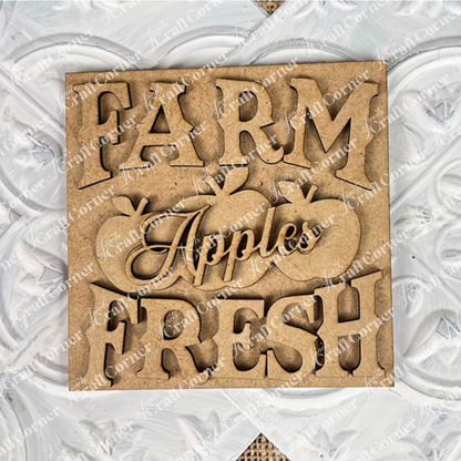 Janet's Craft Corner Farm Fresh Apples Square: Wooden sign with "FARM FRESH Apples" cutout letters and three apple shapes, ideal for DIY home decor in small spaces, displayed on a white textured surface.
