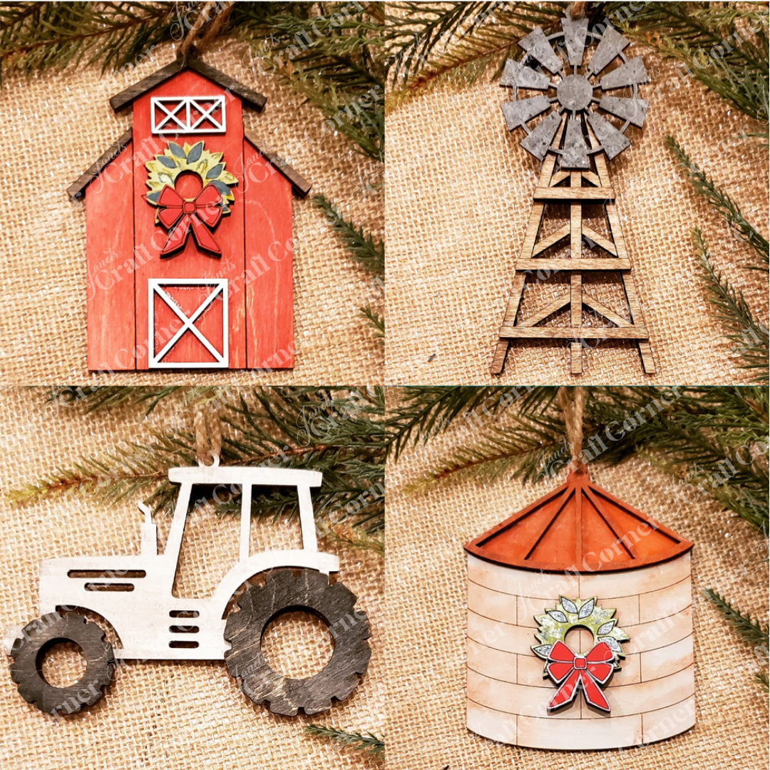 Explore Janet's Craft Corner's DIY Decoration Kits with the Farm Life Christmas Ornaments set, featuring four rustic designs: a red barn, a windmill, a tractor, and a silo. Each ornament is adorned with festive holiday decorations such as bows and wreaths on a burlap backdrop with evergreen branches, perfectly capturing the spirit of farm life.