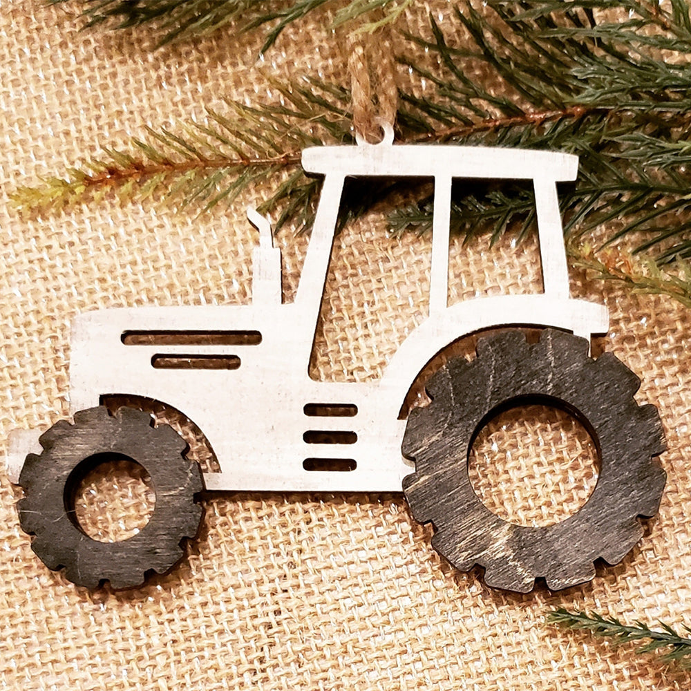 Enhance your holiday décor with Janet's Craft Corner's "Farm Life Christmas Ornaments - Set of 4 | DIY Decoration Kits," which includes a wooden tractor ornament that features a white frame and black wheels, beautifully displayed against a burlap background adorned with pine branches. These charming DIY kits capture the essence of farm life, offering a rustic and festive touch ideal for Christmas ornaments.