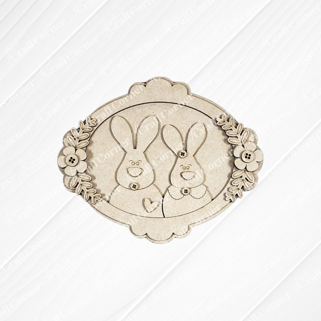 Bring charm to your space with Janet's Craft Corner Easter Decor Set – a DIY kit featuring an ornate oval wooden plaque with two smiling cartoon bunnies, perfect for handmade seasonal decor. Choose from 5 designs!.