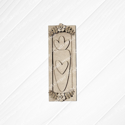 Janet's Craft Corner Easter Decor Set, a DIY seasonal home decor kit (Choice of 5), includes a rectangular wooden plaque with two vertical hearts and floral accents, adding handcrafted charm to any space with its textured, diagonal-line background.