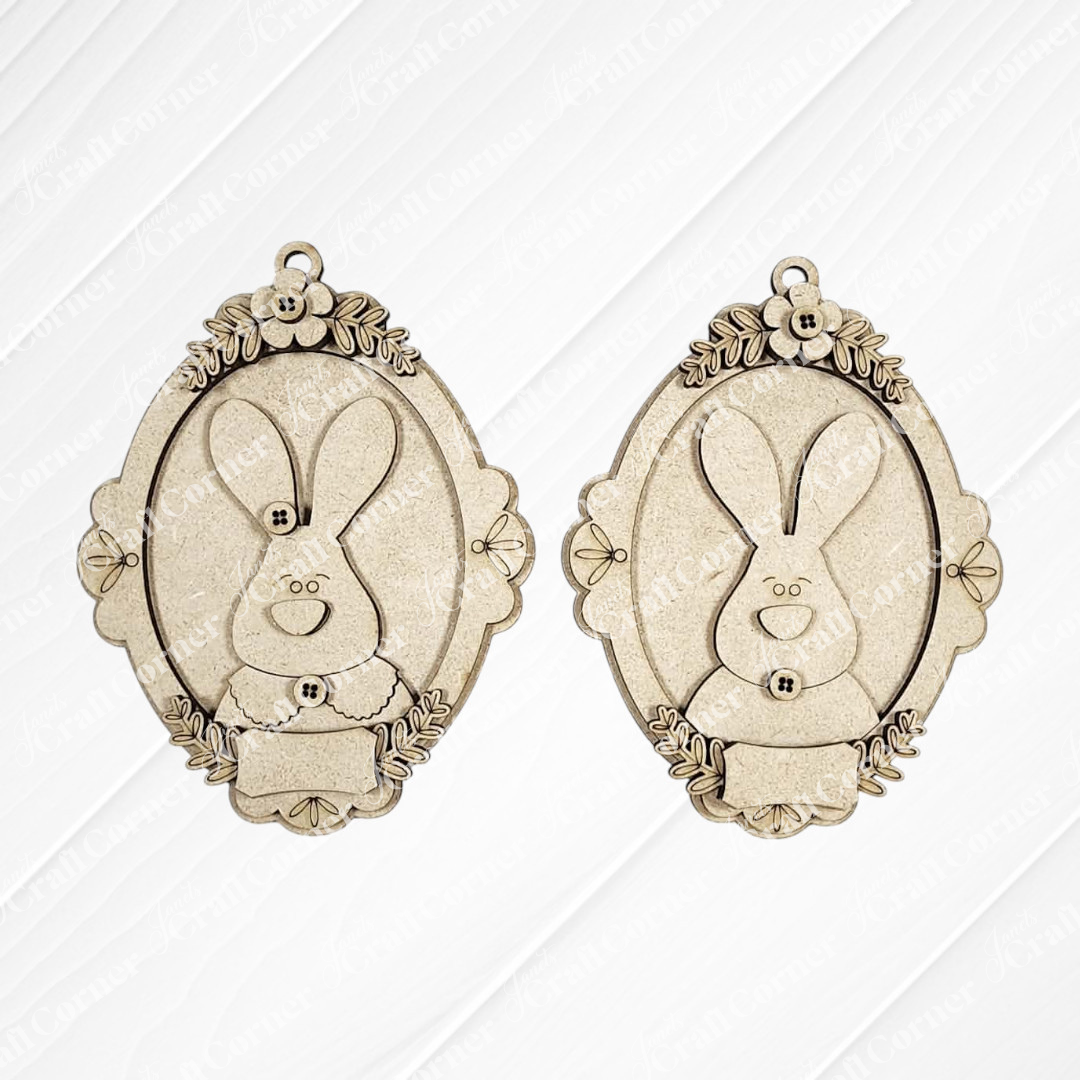 Janet's Craft Corner Framed Easter Bunny Basket Tags are two ornate, oval pendants with floral details and smiling bunny faces—ideal as personalized Easter décor or for DIY craft kits.