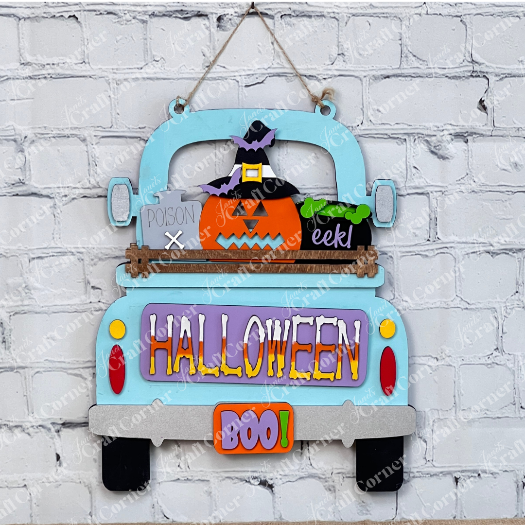 This delightful DIY home decor kit features Janet's Craft Corner's Halloween Pumpkin Interchangeable Insert, showcased on a truck with a cheerful pumpkin wearing a witch hat. The vibrant "HALLOWEEN" and "BOO!" text enhance its festive appeal. Accompanied by a plant, candle, and cutting boards set against a brick wall backdrop, it's ideal for those who enjoy interchangeable craft inserts.