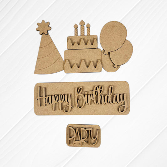Various wooden cutouts including a party hat, a birthday cake with candles, balloons, and the words "Happy Birthday" and "Party" from Janet's Craft Corner are beautifully displayed on a white background. These components are perfect for creating your own customized Birthday Interchangeable Insert as part of your DIY home decor projects.