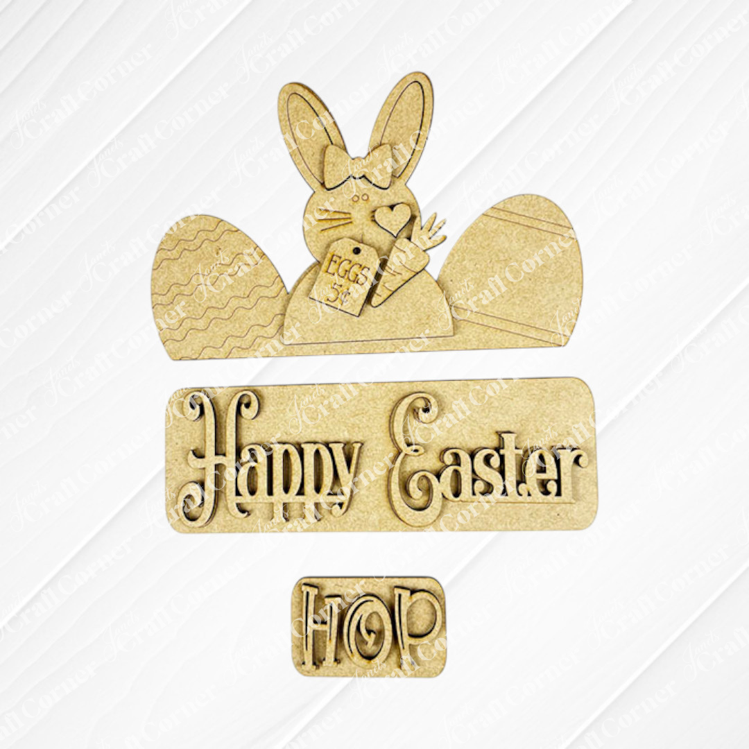 This Easter Bunny Interchangeable Insert from Janet's Craft Corner is a delightful wooden decoration kit, featuring an Easter Bunny holding a "Eggs 5¢" sign and surrounded by two egg shapes. The words "Happy Easter" and "Hop" are intricately carved beneath in decorative letters, making it ideal for DIY craft enthusiasts or as versatile home decor.
