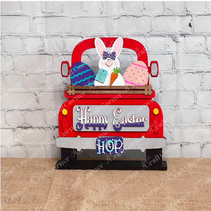 The Happy Easter Bunny Interchangeable Insert from Janet's Craft Corner is a DIY home decor kit with 3 pieces, featuring a truck with a bunny, colorful eggs, and carrot. Adorned with "Happy Easter" and "Hop," it's perfect against on a red antique truck.
