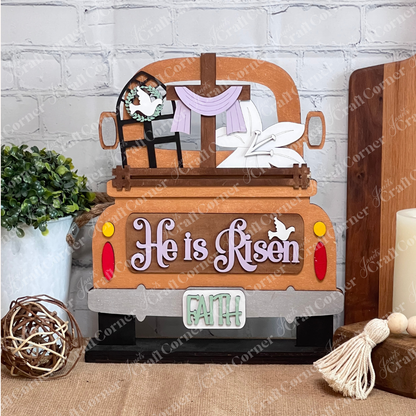 This delightful DIY craft kit from Janet's Craft Corner features a wooden decoration that shows the rear of a truck embellished with Easter motifs. It includes a cross draped with purple cloth, lilies, and a dove in the window. The phrases "He is Risen" and "FAITH" complete this enchanting piece, ideal for interchangeable insert projects.