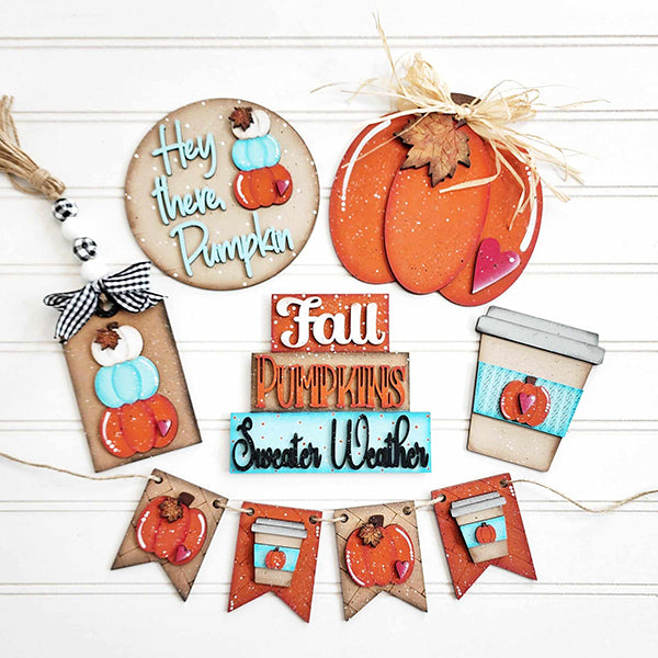 The Hello Pumpkin Decor Set from Janet's Craft Corner is a DIY home decor kit that includes six pieces of assorted fall-themed decorations. This set features hand-painted items such as a pumpkin sign, coffee cup, and tags with pumpkins, along with plaques labeled "Fall Pumpkins" and "Sweater Weather." To complete the look, it also comes with a charming banner of pumpkins and leaves.