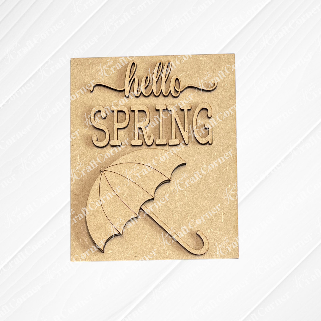 Janet's Craft Corner Spring Switchable Farmhouse Signs - DIY Seasonal Wood Decor Kit features a laser-cut "hello SPRING" sign with umbrella illustration, ideal for DIY projects or tiered tray decor on a light background.
