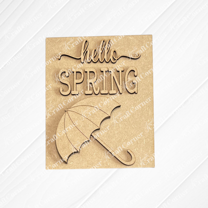Janet's Craft Corner Spring Switchable Farmhouse Signs - DIY Seasonal Wood Decor Kit features a laser-cut "hello SPRING" sign with umbrella illustration, ideal for DIY projects or tiered tray decor on a light background.