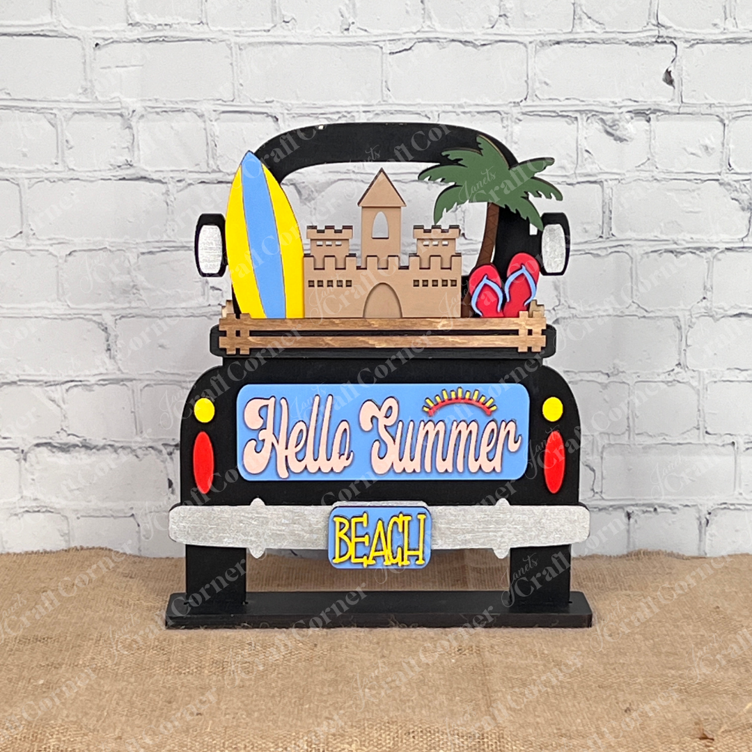 Introducing the Summer Beach Interchangeable Insert, a DIY home decor kit from Janet's Craft Corner. This wooden summer-themed decoration showcases a delightful sandcastle, surfboards, and palm trees. The sign displays "Hello Summer" in colorful letters, making it an ideal piece for adding a vibrant touch to your space.