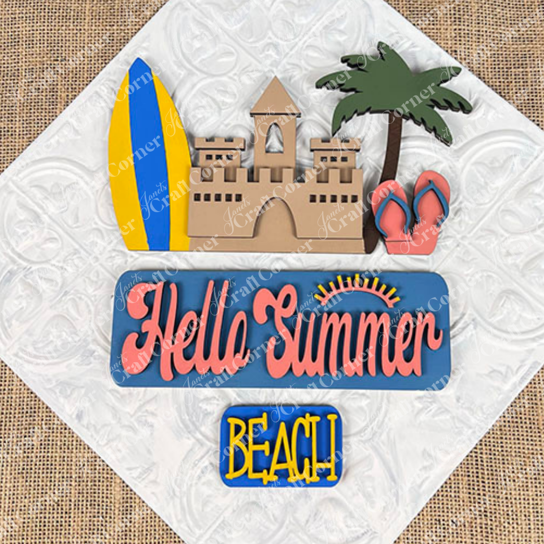 The Summer Beach Interchangeable Insert from Janet's Craft Corner features a textured decorative sign with a sandcastle, surfboard, palm tree, and flip-flops. It displays "Hello Summer" alongside a sun graphic above the bold word "BEACH," making it an ideal DIY home decor kit to add style to your space!