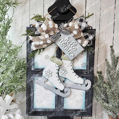 The "Hello Winter Window Hanger" from Janet's Craft Corner showcases festive winter decor, including ice skates and a welcoming "hello winter" sign, enhanced by pine branches and a black and white gingham bow. A snowflake-decorated white wooden background adds the finishing touch, making it ideal for home décor this season.