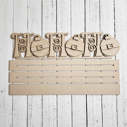 This "NOEL" wooden sign from Janet's Craft Corner features decorative letters and two ornamental Christmas baubles, along with four slots for displaying personalized home décor items. The whitewashed wooden plank background adds a rustic charm, making it an ideal Ho Ho Ho Shelf Sitter for festive displays.