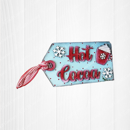 Add a festive touch with Janet's Craft Corner Hot Cocoa Mini Shelf Sitters—a DIY seasonal home decor kit featuring a blue tag, red/white ribbon, "Hot Cocoa" text, snowflakes, and a red mug with whipped cream. Set of 1.