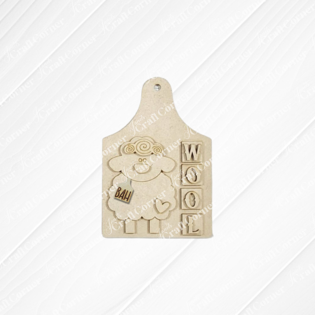 Janet's Craft Corner's Heirloom Decor Set offers a DIY kit featuring a beige cutting board-shaped plaque with a cartoon sheep saying "BAH!" and "WOOL" in raised letters—ideal for seasonal home decor or creative projects.