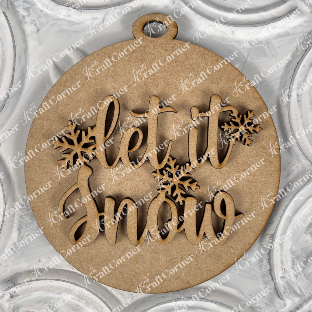 Introducing the "Round Christmas Ornaments" DIY Decoration Kit from Janet's Craft Corner. This round wooden ornament features the phrase "Let it Snow" in elegant cursive and is accented with delicate snowflakes. Set against a textured white background with a decorative pattern, it's the perfect festive decoration for your crafting endeavors this Christmas season.